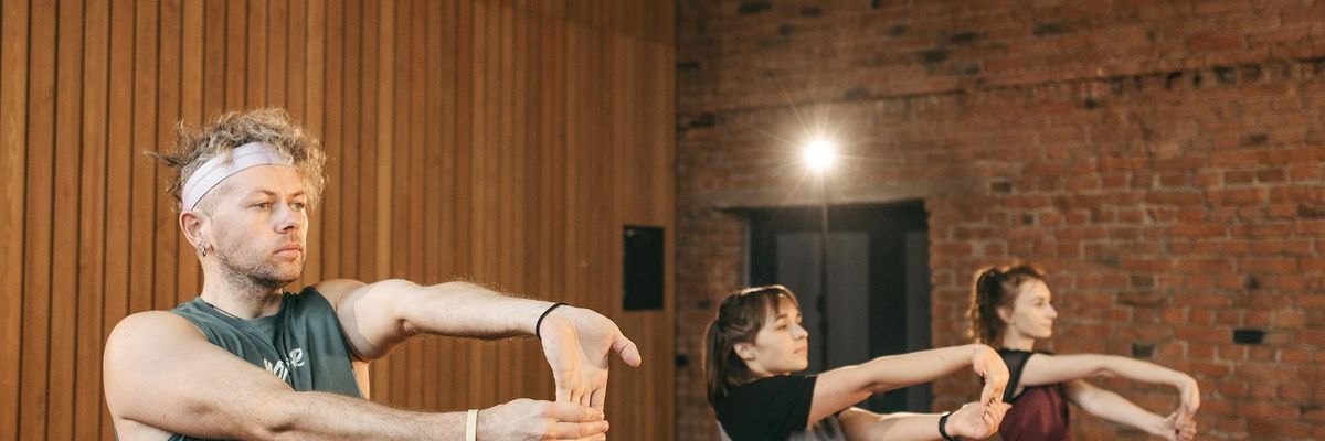 A group of people happily engaging in a light fitness class.